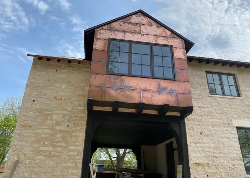 Copper metal panel facade on a stone building for Roof Repair in Springdale
